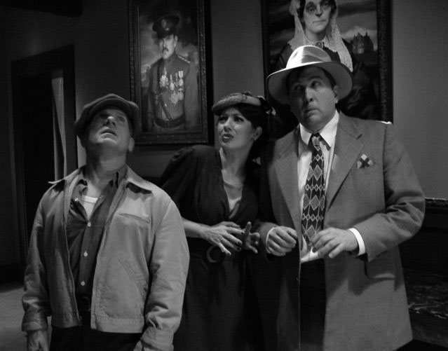 Another view of the Cavinder hall of family portraits, set by production designer Anthony Tremblay. Adjudging the artworks with a certain level of trepidation are Dan Conroy as cabbie Happy Codburn, Jennifer Blair as reporter Billy Tuesday and Daniel Roebuck as reporter 8 O'Clock Farraday. Photograph courtesy Trish Geiger.